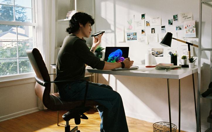 Person working at a sunlit desk with a laptop
